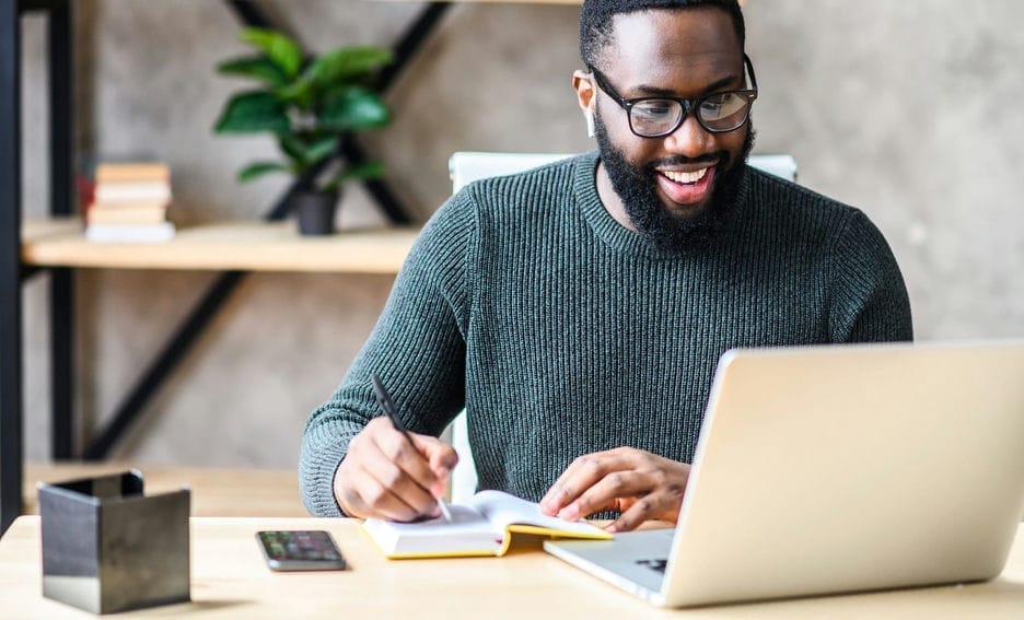 A man sits at his computer, learning how to improve IT customer service.