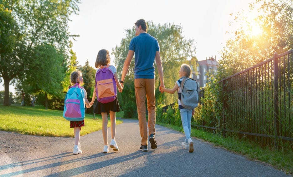 Parent taking primary school students to school