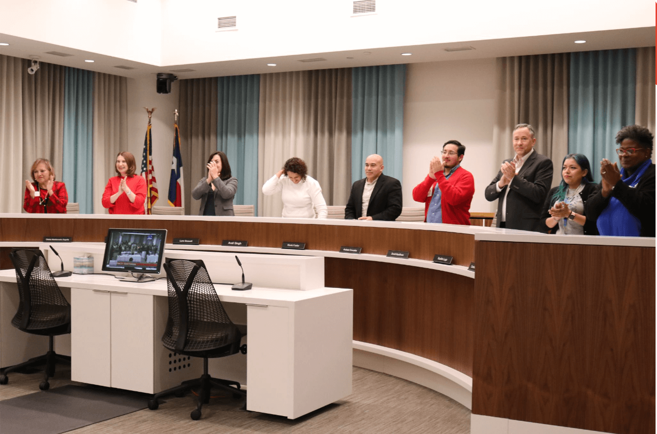 AISD Trustees celebrating during a meeting