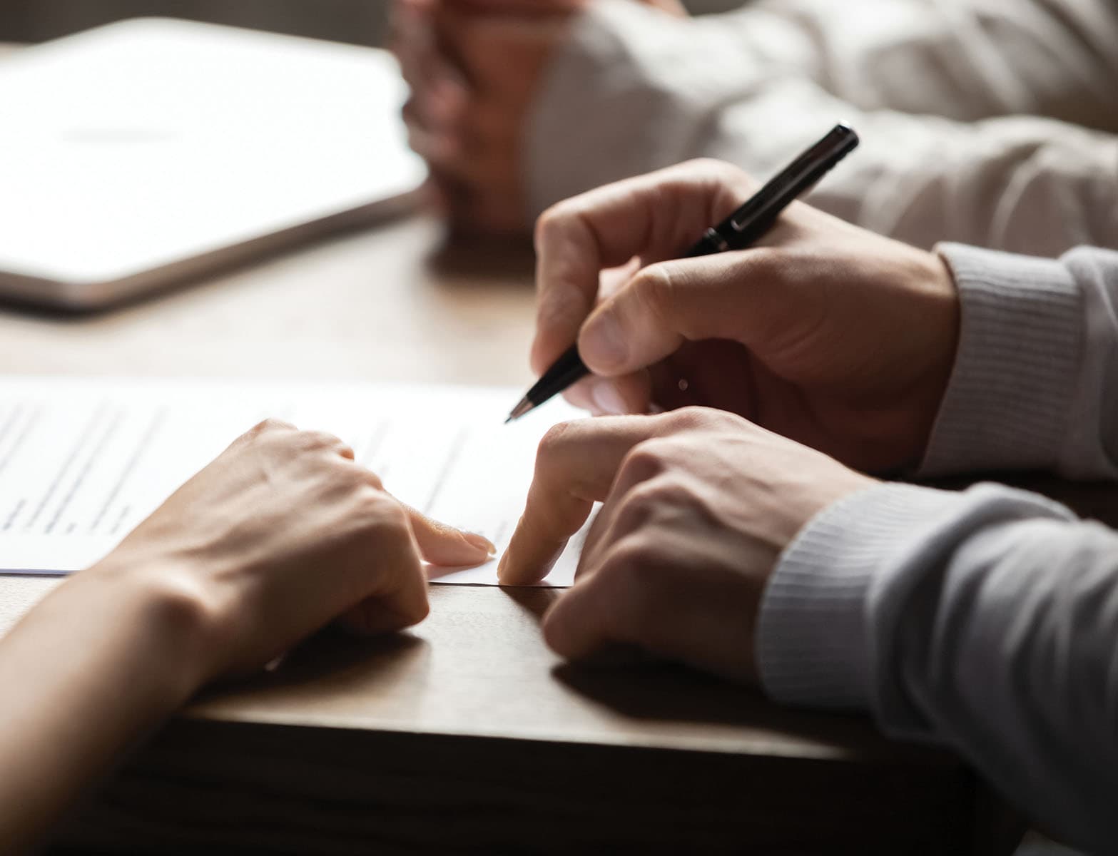 Solicitor pointing at contract showing client where to write signature