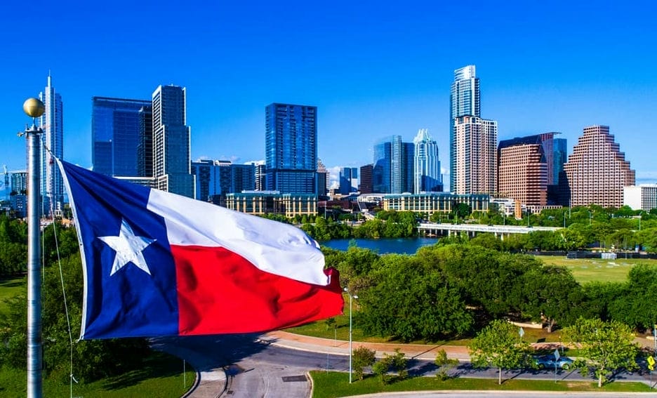 Texas flag on flagpole amidst a city