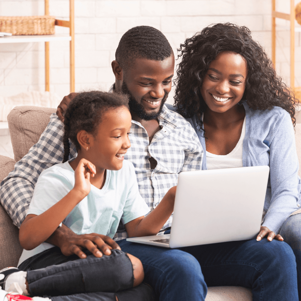 Family looking sitting on couch looking at laptop